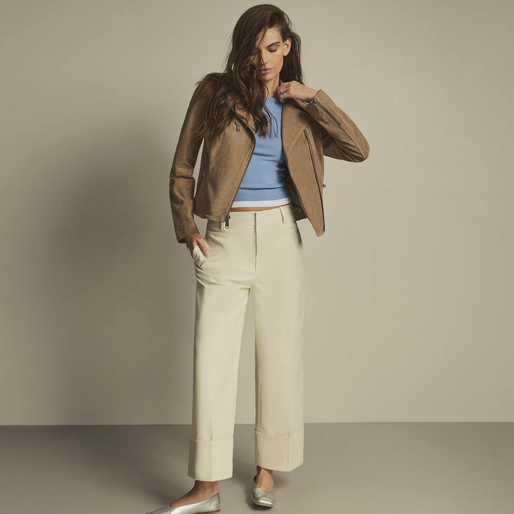 Women’s warm beige suede moto jacket styled with an ivory wide-leg outfit, three zip pockets and fitted sleeves.