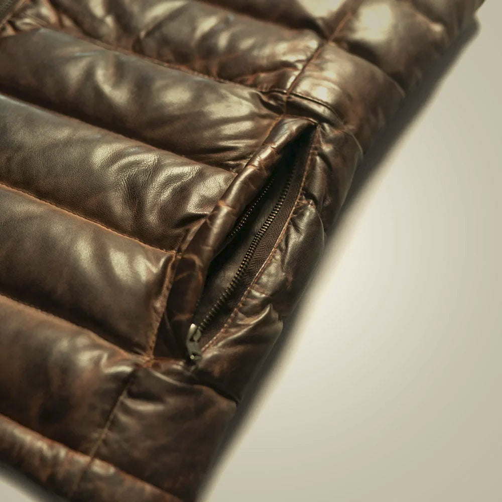 Close-up of YKK zip hand pocket set into the chocolate-brown baffles of a waxed leather vest